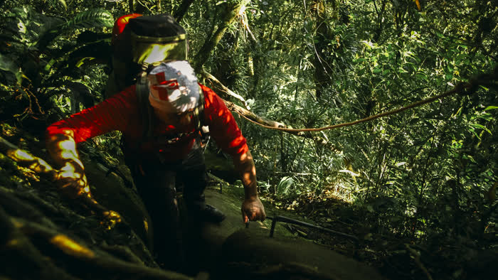 Voluntário em travessia técnica na mata